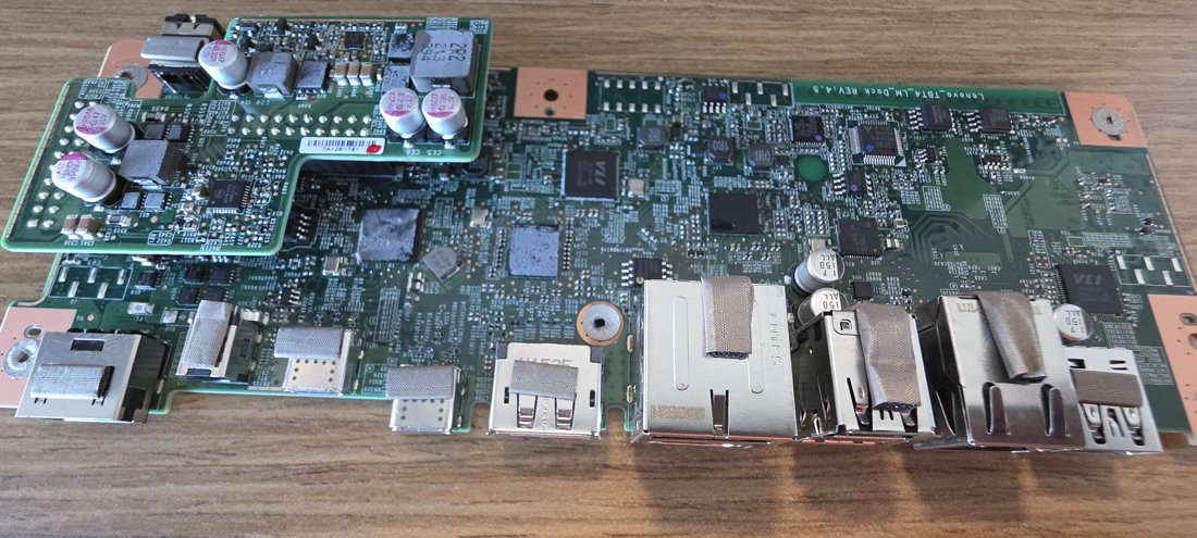 Inside a Lenovo Thunderbolt 4 dock: mid-grade board with a full wall of shielded ports, power daughterboard and copper ground floods