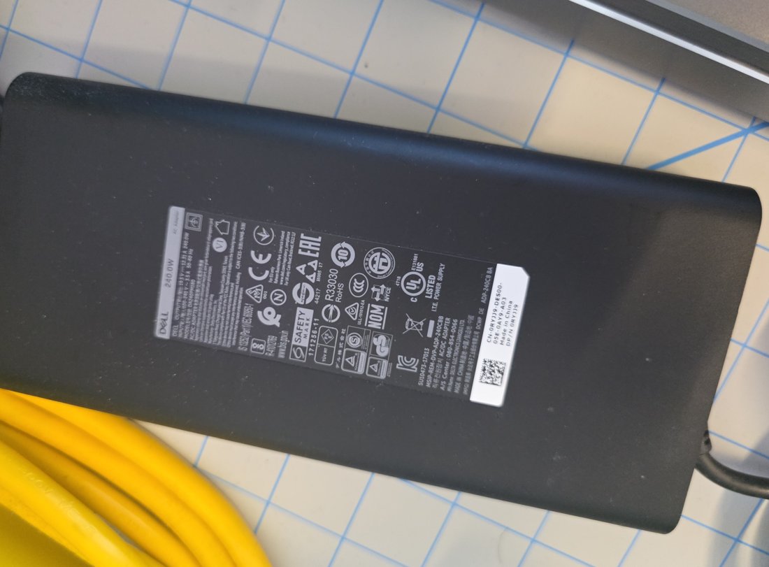 Dell 240 W gaming laptop power brick label showing wattage and part numbers